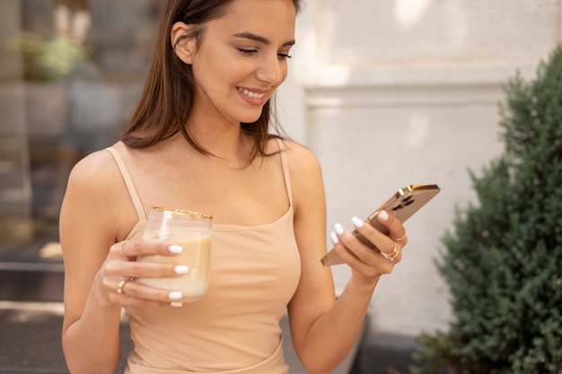 Mujer joven bebiendo café helado