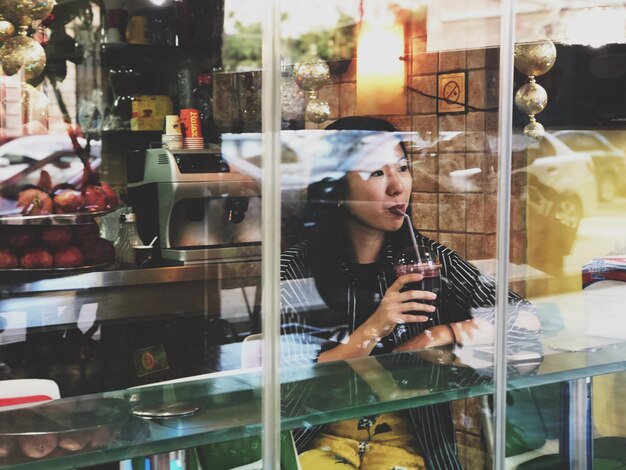 Foto mujer joven bebiendo en un restaurante