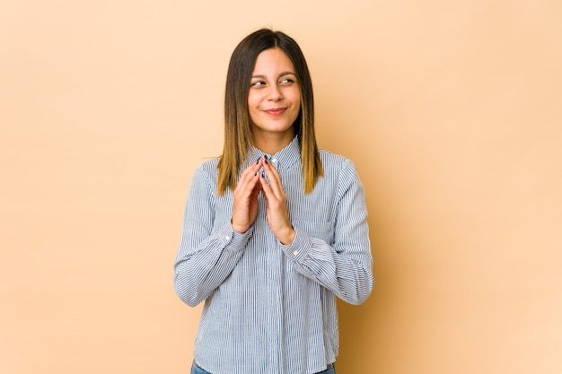 Mujer joven en beige haciendo plan en mente, creando una idea.