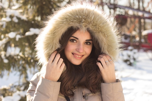 Mujer joven belleza en el parque de invierno en un día frío de invierno