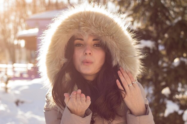 Mujer joven belleza en el parque de invierno en un día frío de invierno