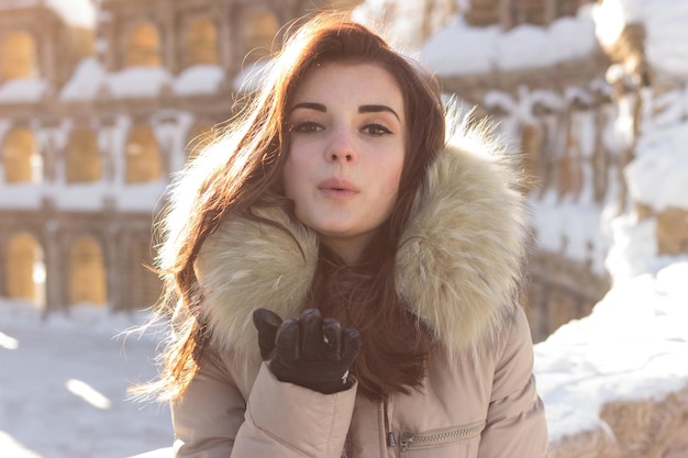 Mujer joven belleza en el parque de invierno en día frío de invierno