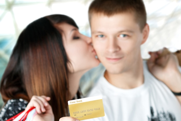 Mujer joven, besar, tenencia, tarjeta de crédito, foco, en, tarjeta