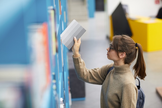 Mujer joven, en, biblioteca