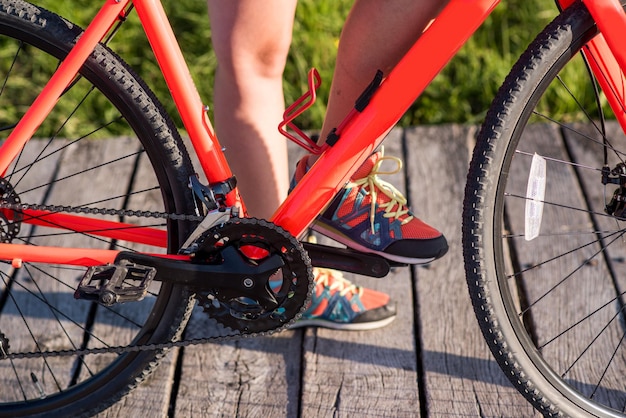 Mujer joven con bicicleta al aire libre en el parque