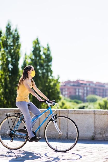 Foto mujer joven en bicicleta en la calle