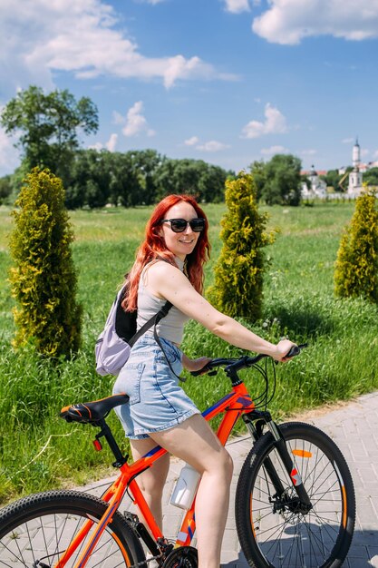 Foto mujer joven en bicicleta en el campo