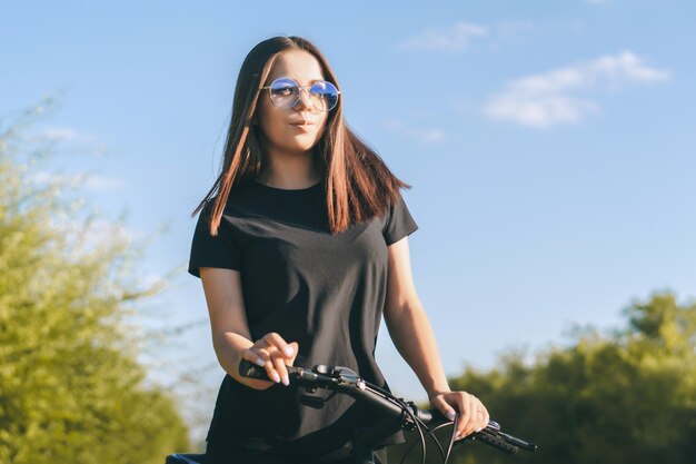 Mujer joven en bicicleta por la carretera