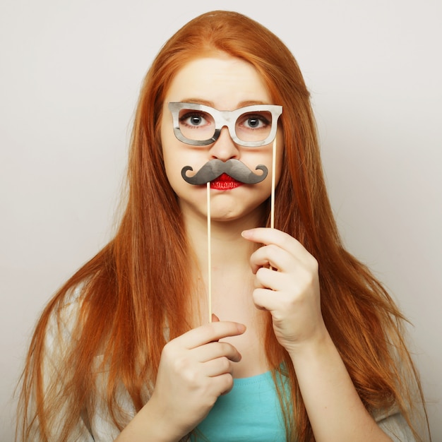 Mujer joven con bigotes falsos.