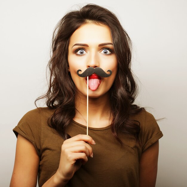 Mujer joven con bigotes falsos.