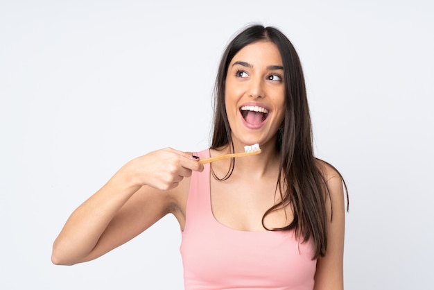 Mujer joven en blanco con un cepillo de dientes