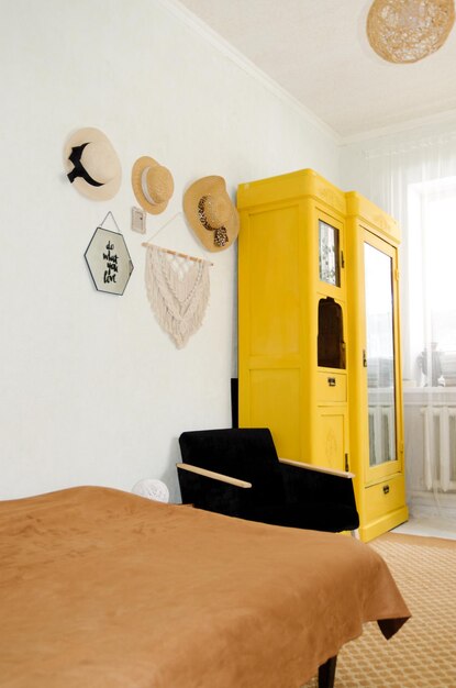 Mujer joven en boina se sienta. un sillón. hogar acogedor, en habitación con disco de música. Gabinete amarillo vintage