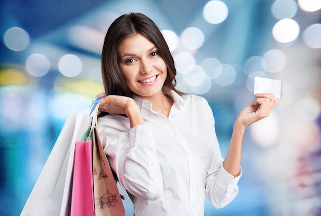 Mujer joven con bolsa de compras y tarjeta de crédito