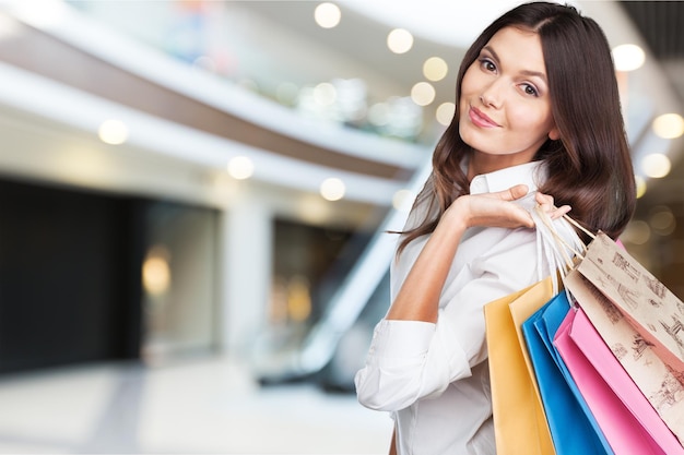 mujer joven, con, bolsas de compras, en, plano de fondo