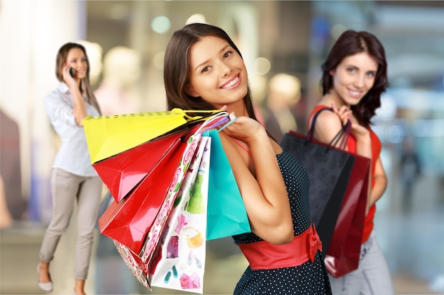 Mujer joven, con, bolsas de compras, en, plano de fondo