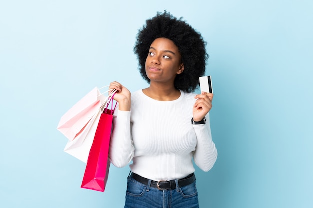 Mujer joven con bolsas de compras y tarjeta de crédito