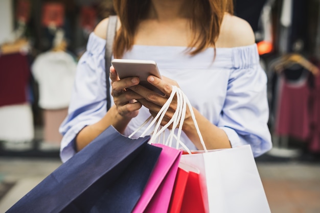 Mujer joven con bolsas de compras en la tienda