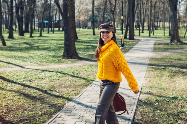 Mujer joven con bolso elegante y vistiendo traje de otoño