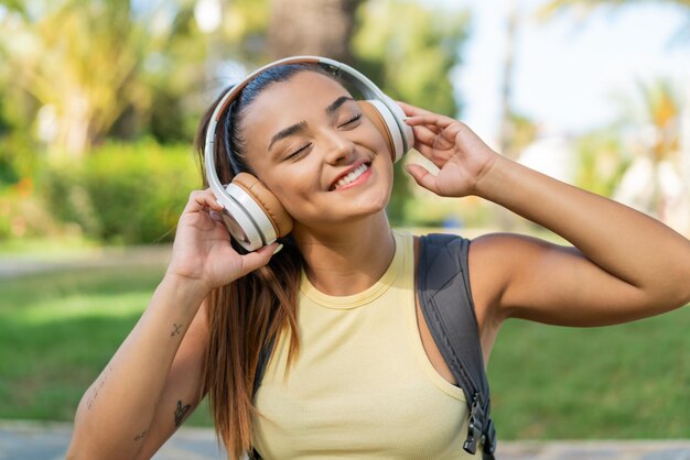 Mujer joven y bonita al aire libre escuchando música