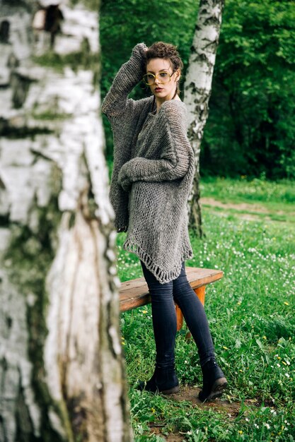 Mujer joven y bonita con anteojos en el bosque