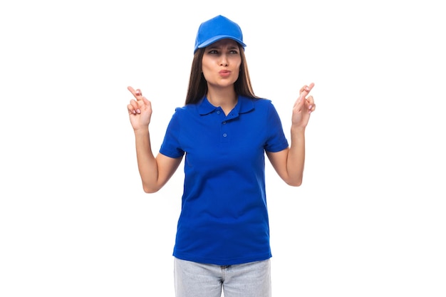 Foto mujer joven bonita en una camiseta de algodón azul y gorra con espacio para la impresión muestra sus manos a la