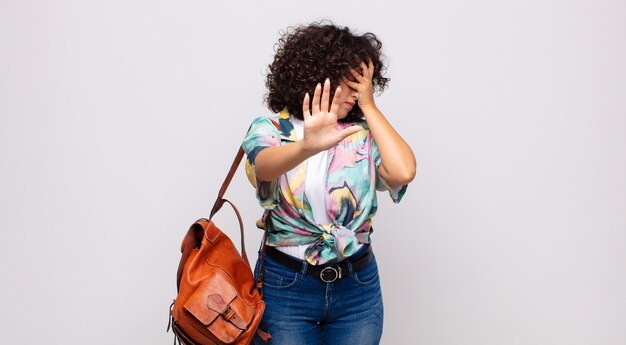 mujer joven y bonita con una camiseta colorida y una mochila