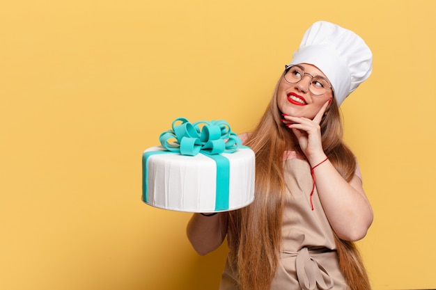 mujer joven y bonita. Concepto de pastel de cumpleaños de expresión de pensamiento o duda