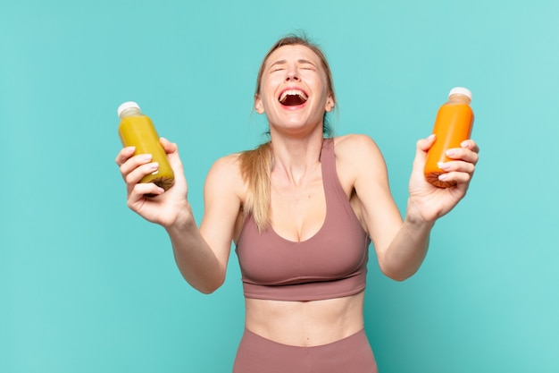 Mujer joven bonita deporte con expresión feliz y celebración batido