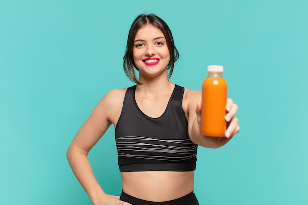 Mujer joven bonita deporte con expresión feliz y celebración batido