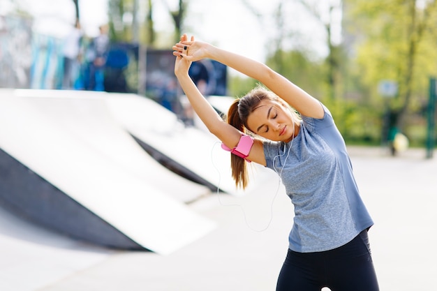 Mujer joven y bonita con ejercicio en el parque en un día soleado