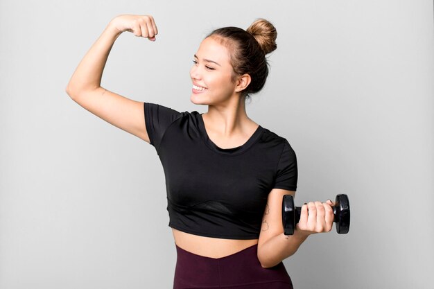 Foto mujer joven y bonita hispana levantando un concepto de fitness con mancuernas