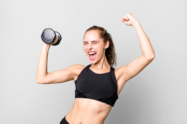 Mujer joven y bonita hispana levantando un concepto de fitness con mancuernas