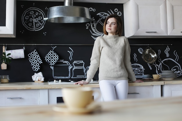 Foto una mujer joven y bonita en el interior de la cocina moderna