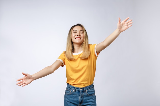 Foto mujer joven y bonita que hace un gesto con los brazos para venir a abrazarla