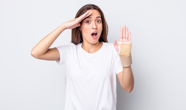 mujer joven y bonita que parece feliz, asombrada y sorprendida. concepto de vendaje de mano