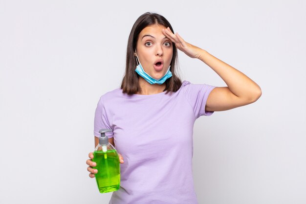 Mujer joven y bonita que parece feliz, asombrada y sorprendida, sonriendo y dándose cuenta de buenas e increíbles noticias.