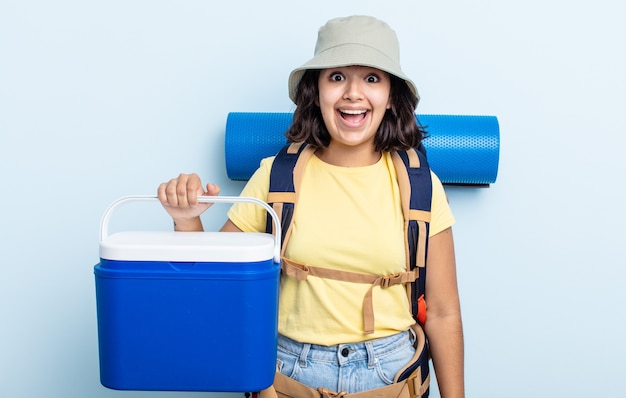 Mujer joven y bonita que parece feliz y gratamente sorprendida. concepto de camping