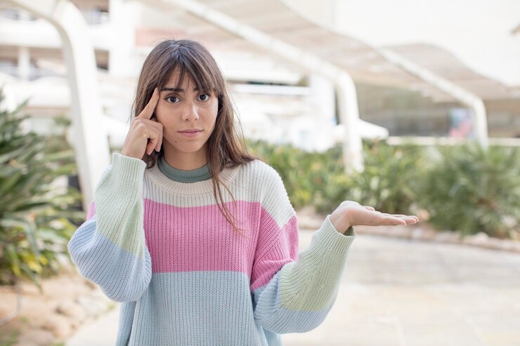 Foto una mujer joven y bonita que se siente confundida y perpleja mostrando que estás loco, loco o loco