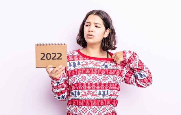 Mujer joven y bonita que se siente estresada, ansiosa, cansada y frustrada. Concepto de calendario 2022