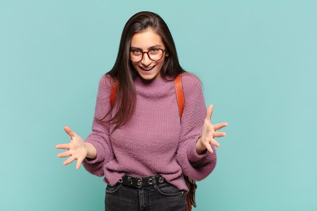 ¿Una mujer joven y bonita que se siente feliz, asombrada, afortunada y sorprendida, como decir omg en serio? Increíble. concepto de estudiante