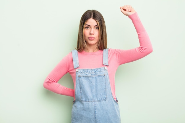 Mujer joven y bonita que se siente seria, fuerte y rebelde levantando el puño protestando o luchando por la revolución