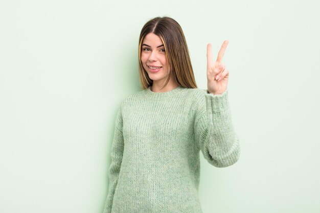 mujer joven y bonita sonriendo y luciendo amistosa, mostrando el número dos