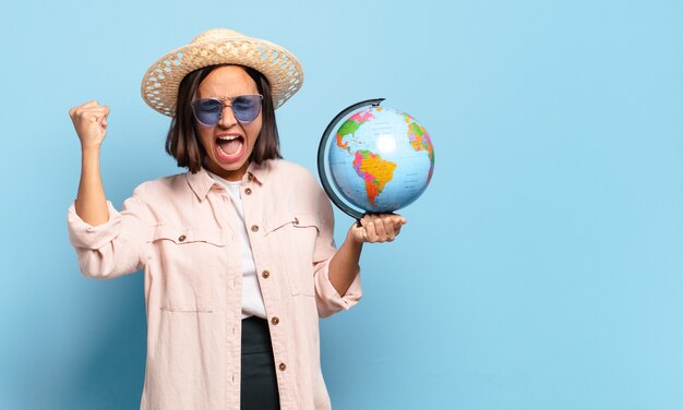 Mujer joven bonita viajera con un mapa del mundo