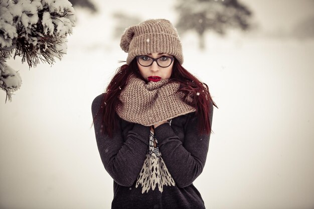 Mujer joven en bosque de invierno