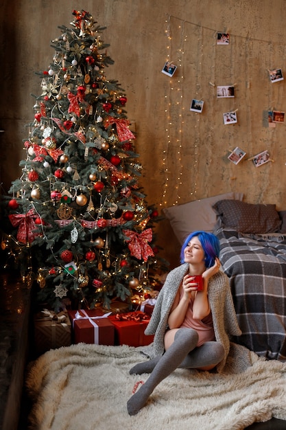 Mujer joven con cabello azul en Navidad