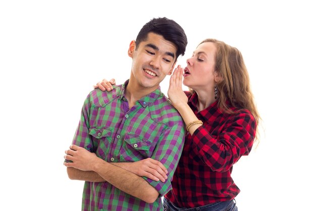 Mujer joven con cabello largo castaño hablando con un joven agradable con cabello oscuro en camisa a cuadros