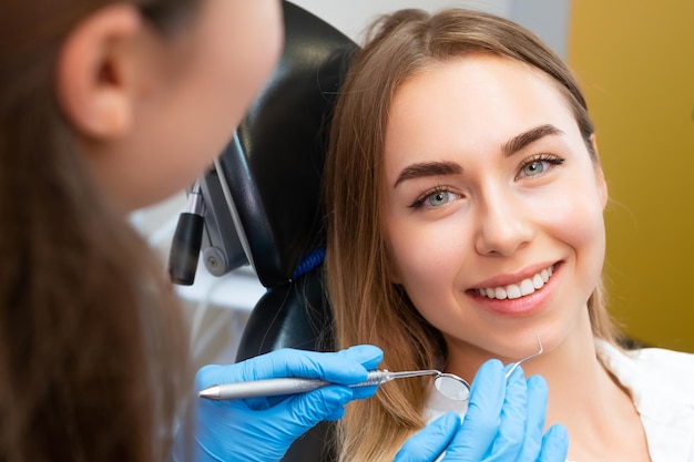 Mujer joven de cabello marrón preparándose para un procedimiento dental con un dentista en una cita en una clínica privada