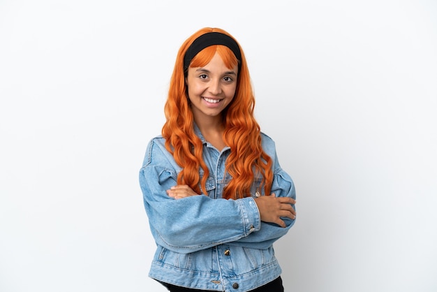 Mujer joven con cabello naranja aislado sobre fondo blanco con los brazos cruzados y mirando hacia adelante