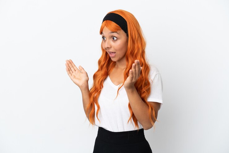 Foto mujer joven con cabello naranja aislado sobre fondo blanco con expresión facial sorpresa