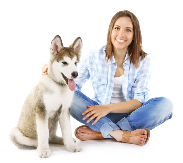 Foto mujer joven con cachorro malamute aislado en blanco